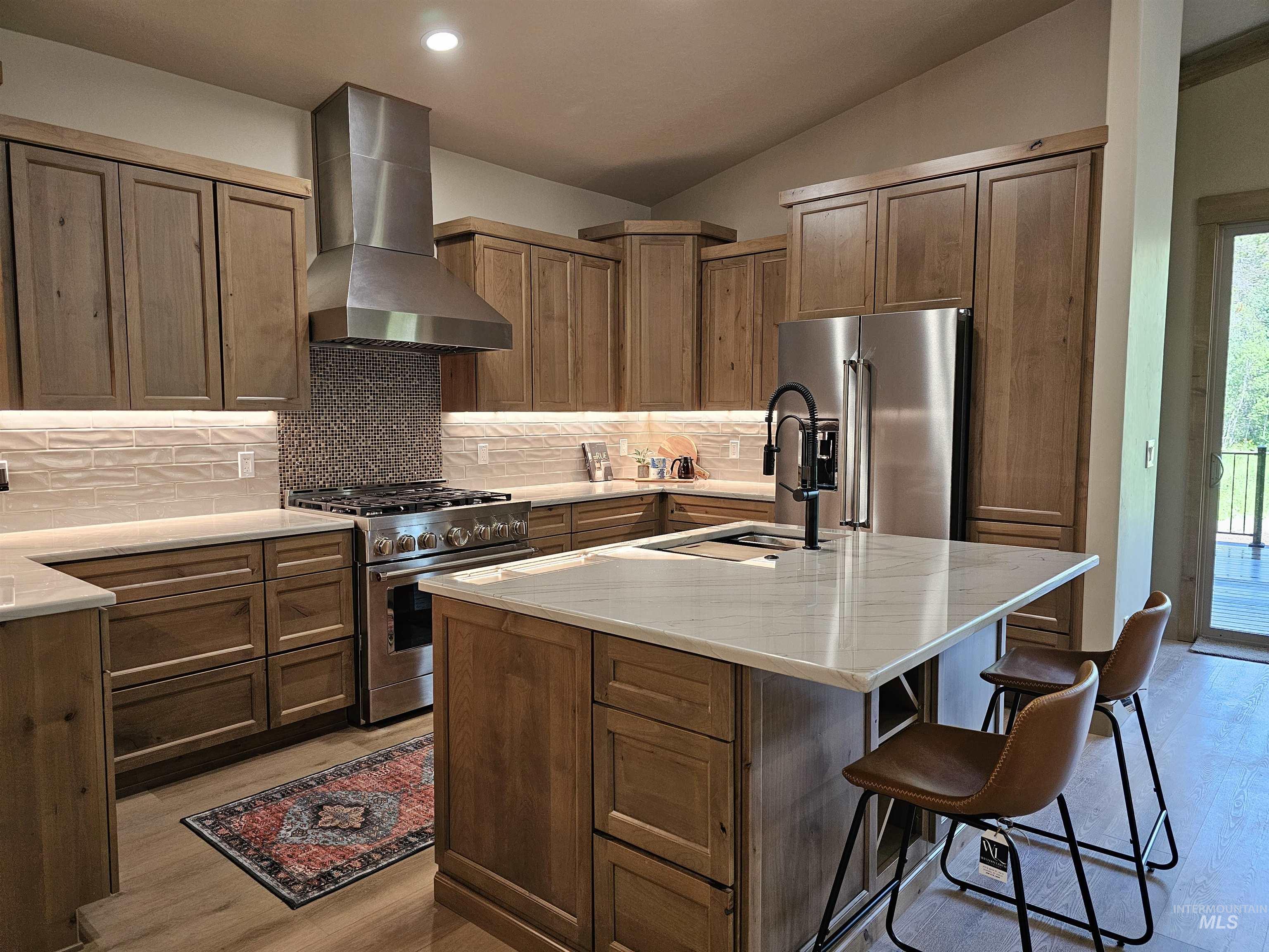 Kitchen features a large island, quartzite countertops and a butler's pantry to keep your counters looking neat and tidy.