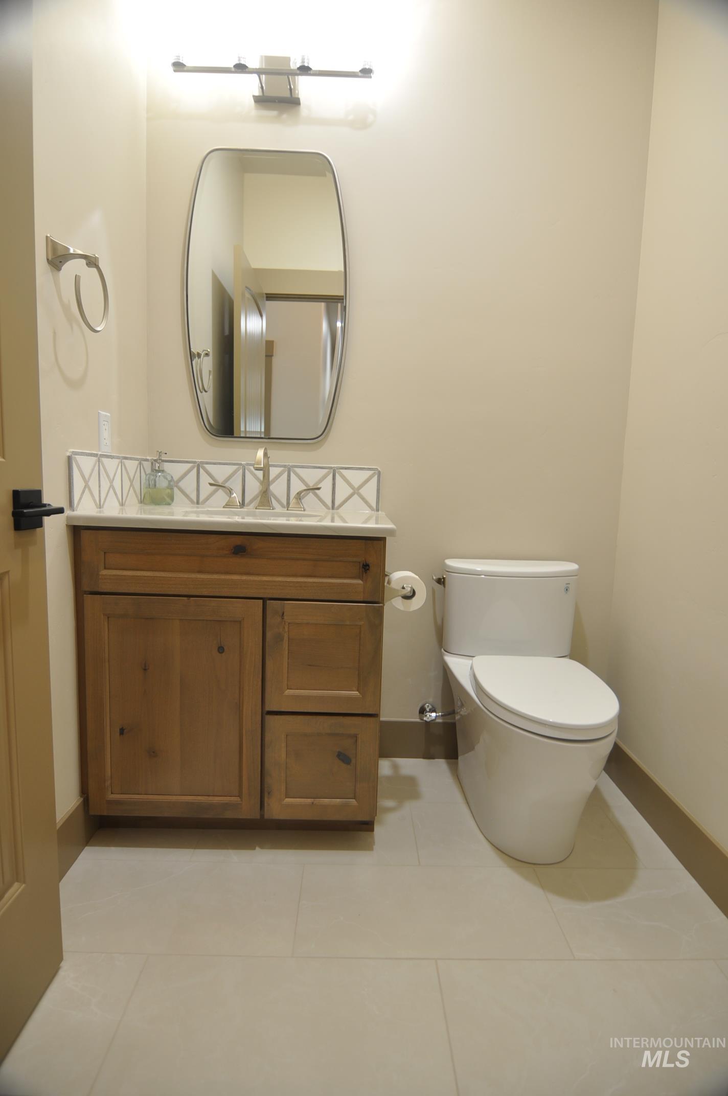 Powder bathroom is located between the entry and living area. Pretty tile accent.