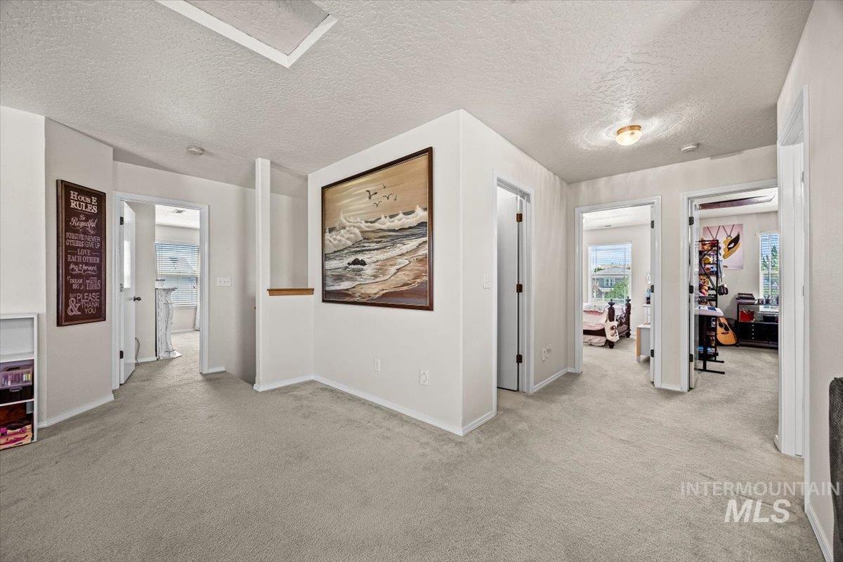 Corridor with carpet floors and a textured ceiling
