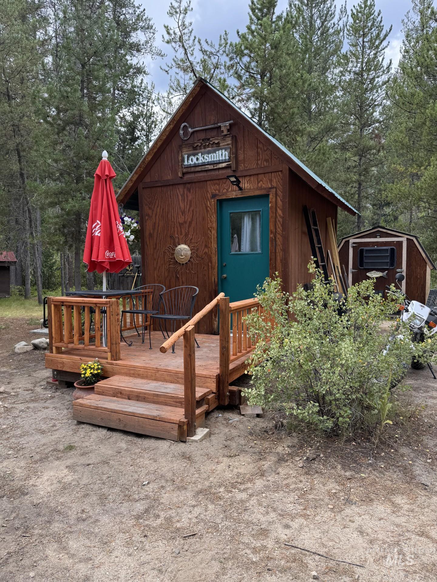 View of front of property with a wooden deck and a shed