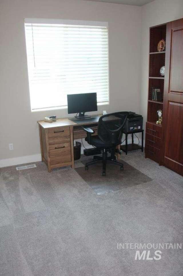 Office with light colored carpet and baseboards