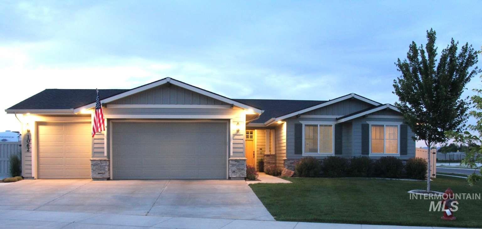 Ranch-style house featuring an attached garage, concrete driveway, a front yard, and stone siding