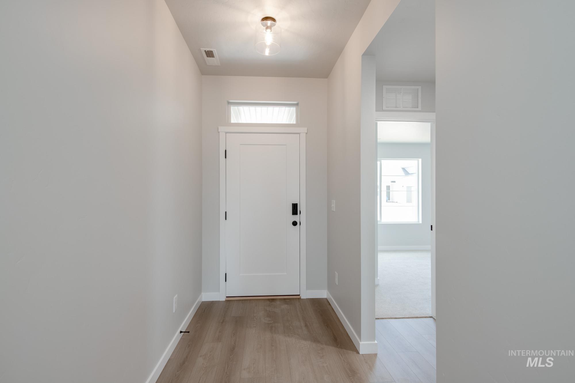 Foyer featuring light wood-style floors and baseboards
