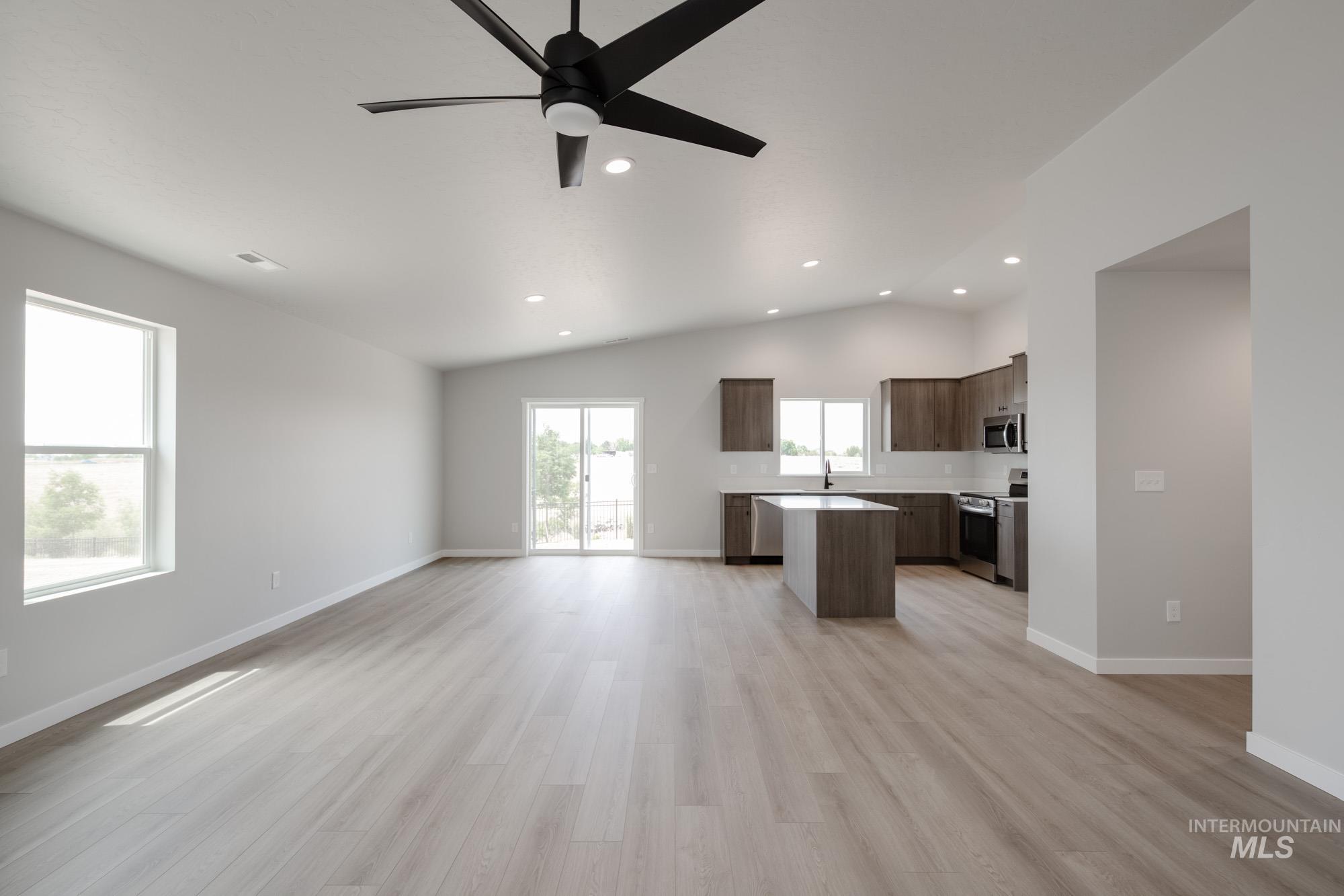 Unfurnished living room featuring recessed lighting, light wood-style flooring, vaulted ceiling, and ceiling fan