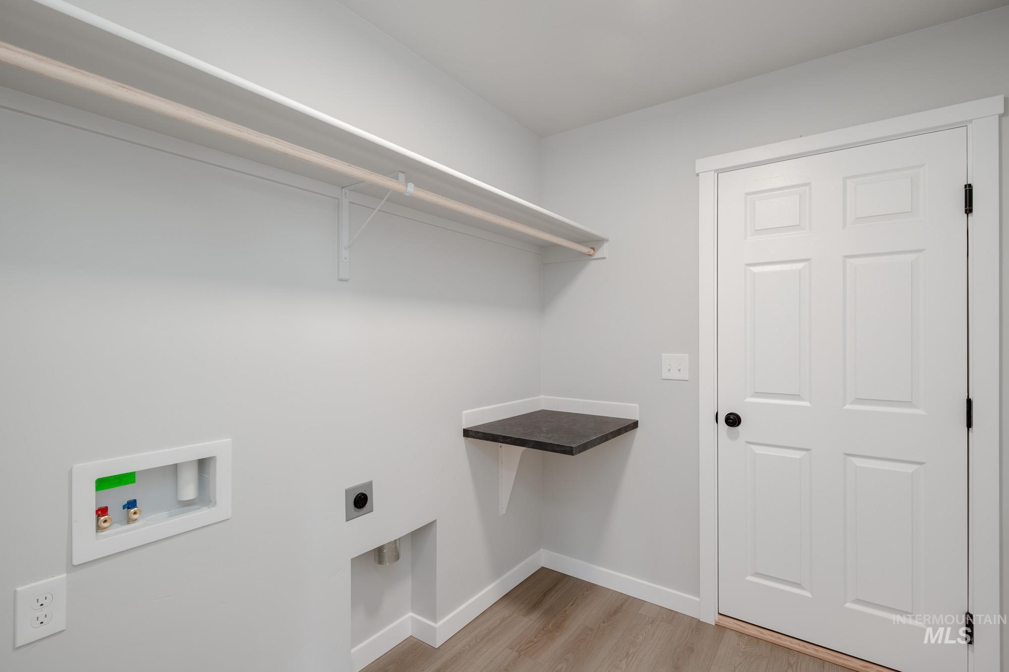Laundry area featuring electric dryer hookup, washer hookup, and light wood-type flooring
