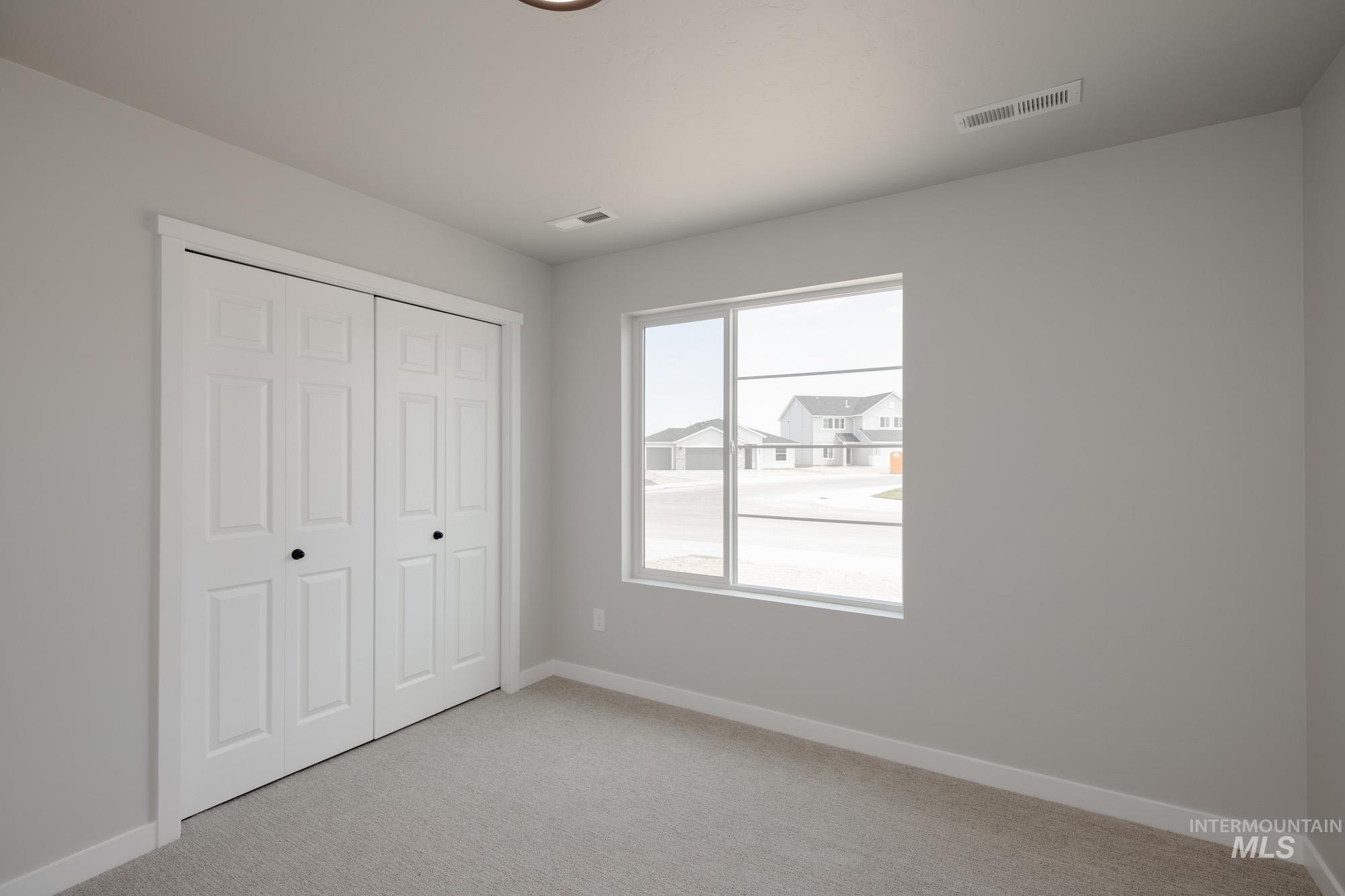 Unfurnished bedroom featuring light colored carpet and a closet