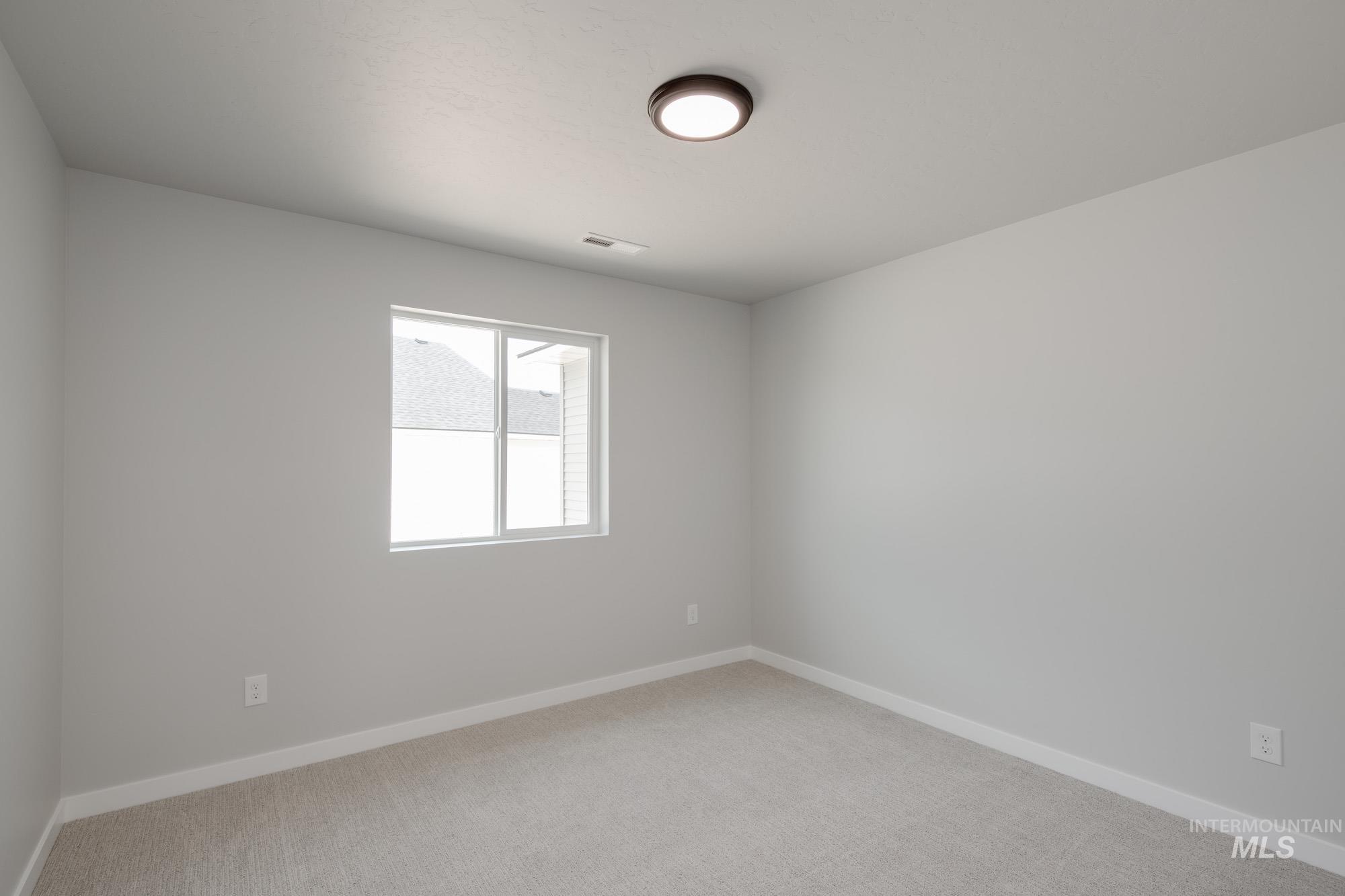 Empty room featuring light carpet and baseboards