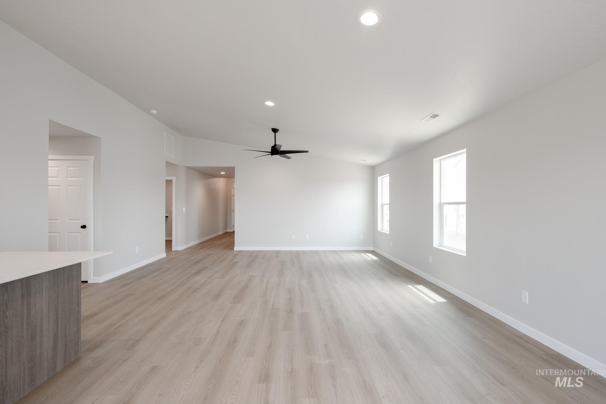 Unfurnished living room featuring ceiling fan, light wood-type flooring, and recessed lighting