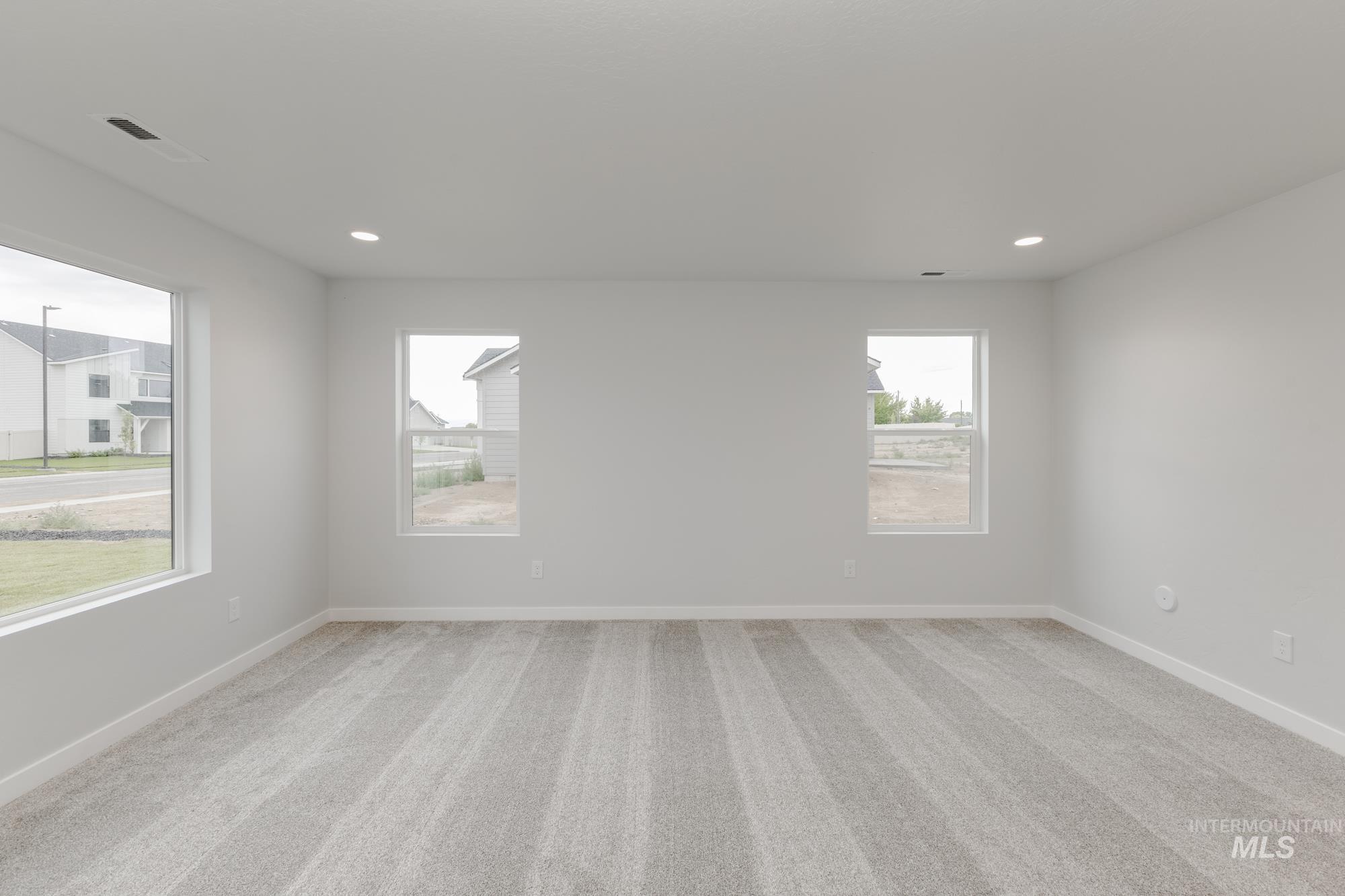Spare room featuring light carpet and recessed lighting