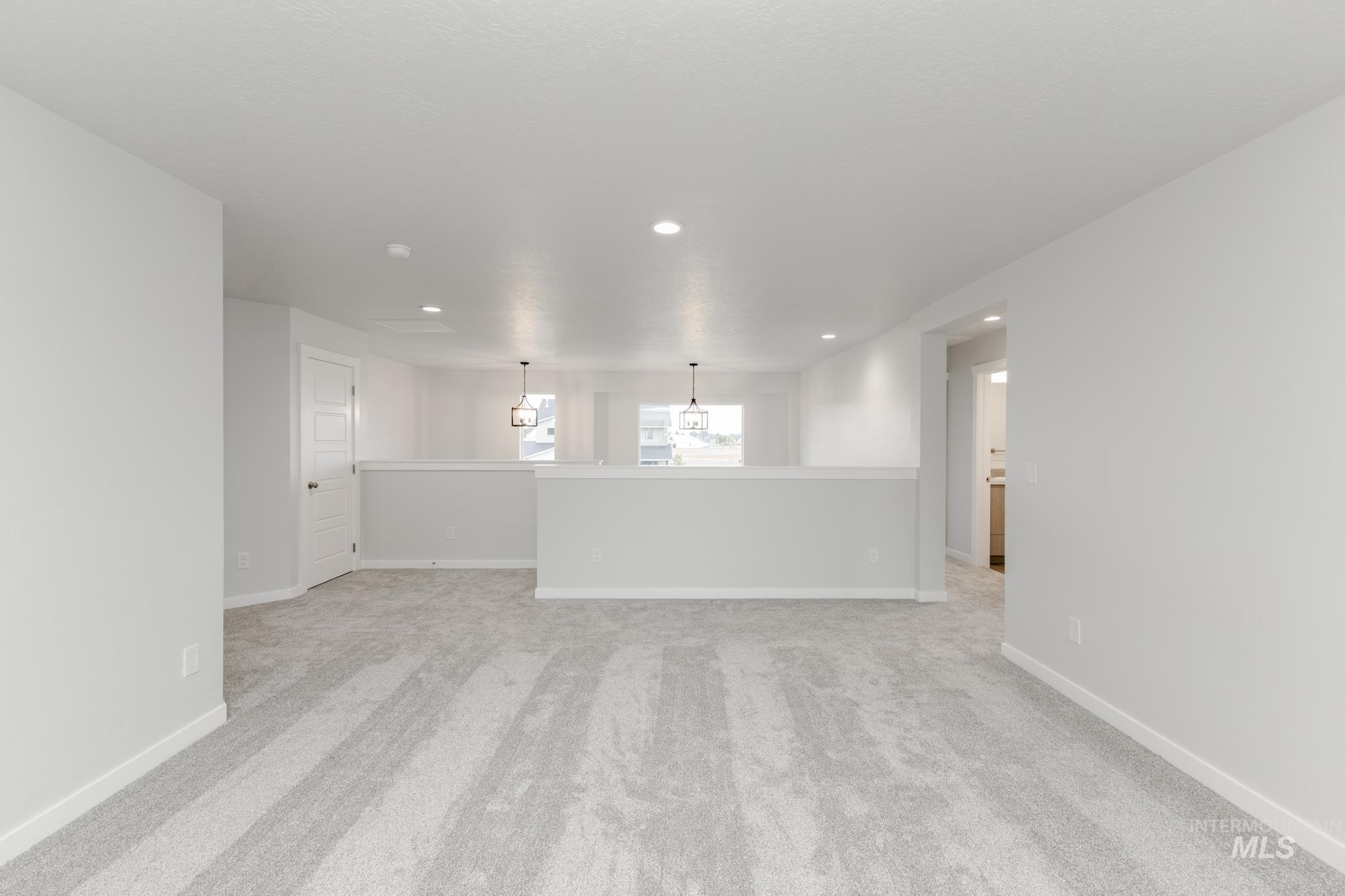 Unfurnished living room featuring recessed lighting and light carpet