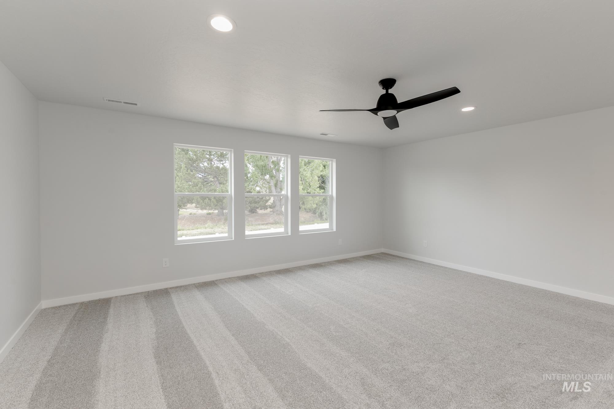Empty room with a ceiling fan, recessed lighting, and light colored carpet