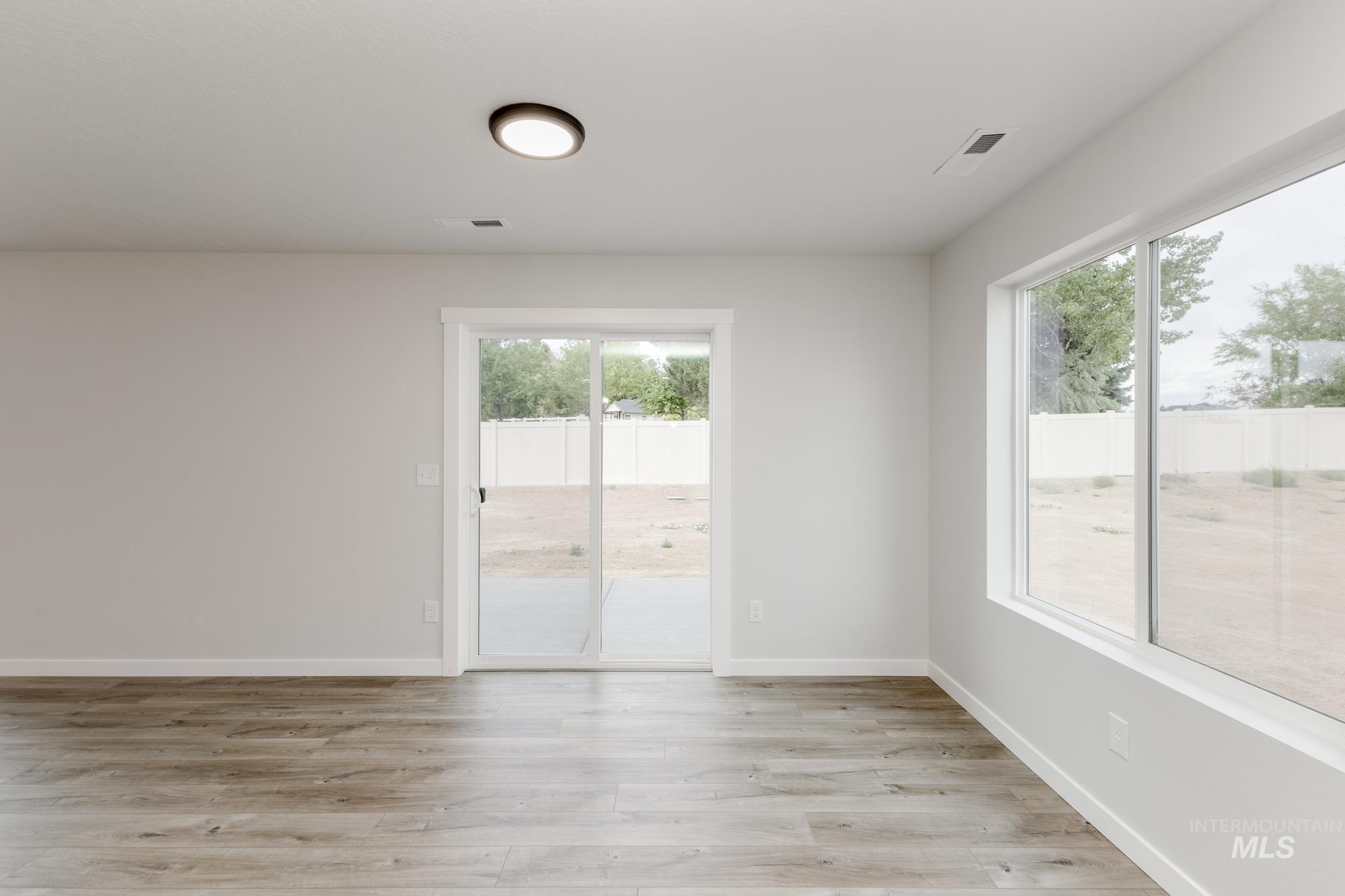 Empty room with healthy amount of natural light and light wood-type flooring