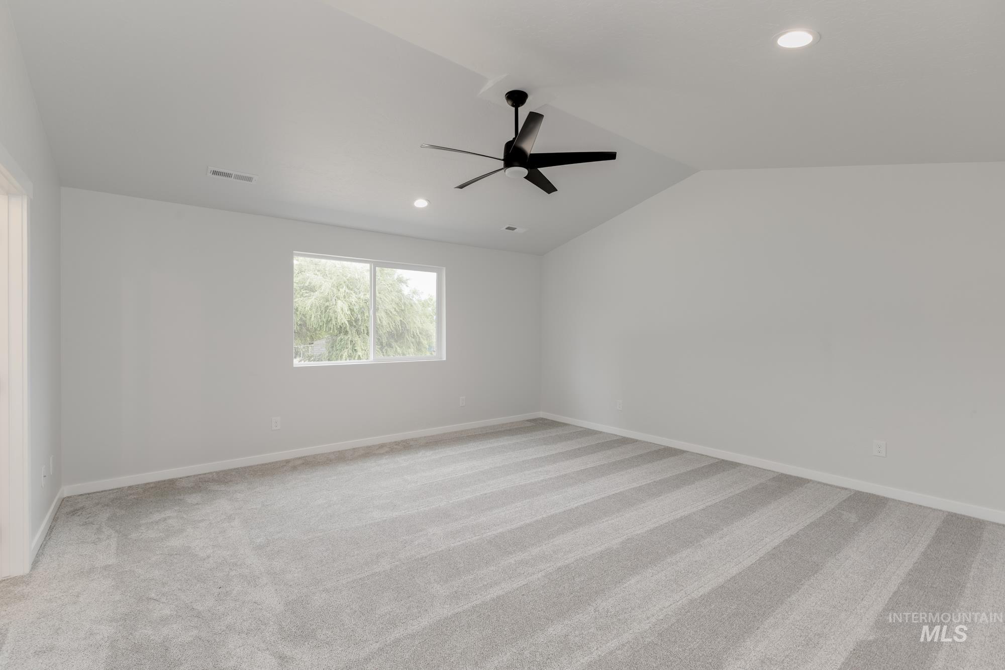 Spare room with a ceiling fan, light colored carpet, recessed lighting, and vaulted ceiling