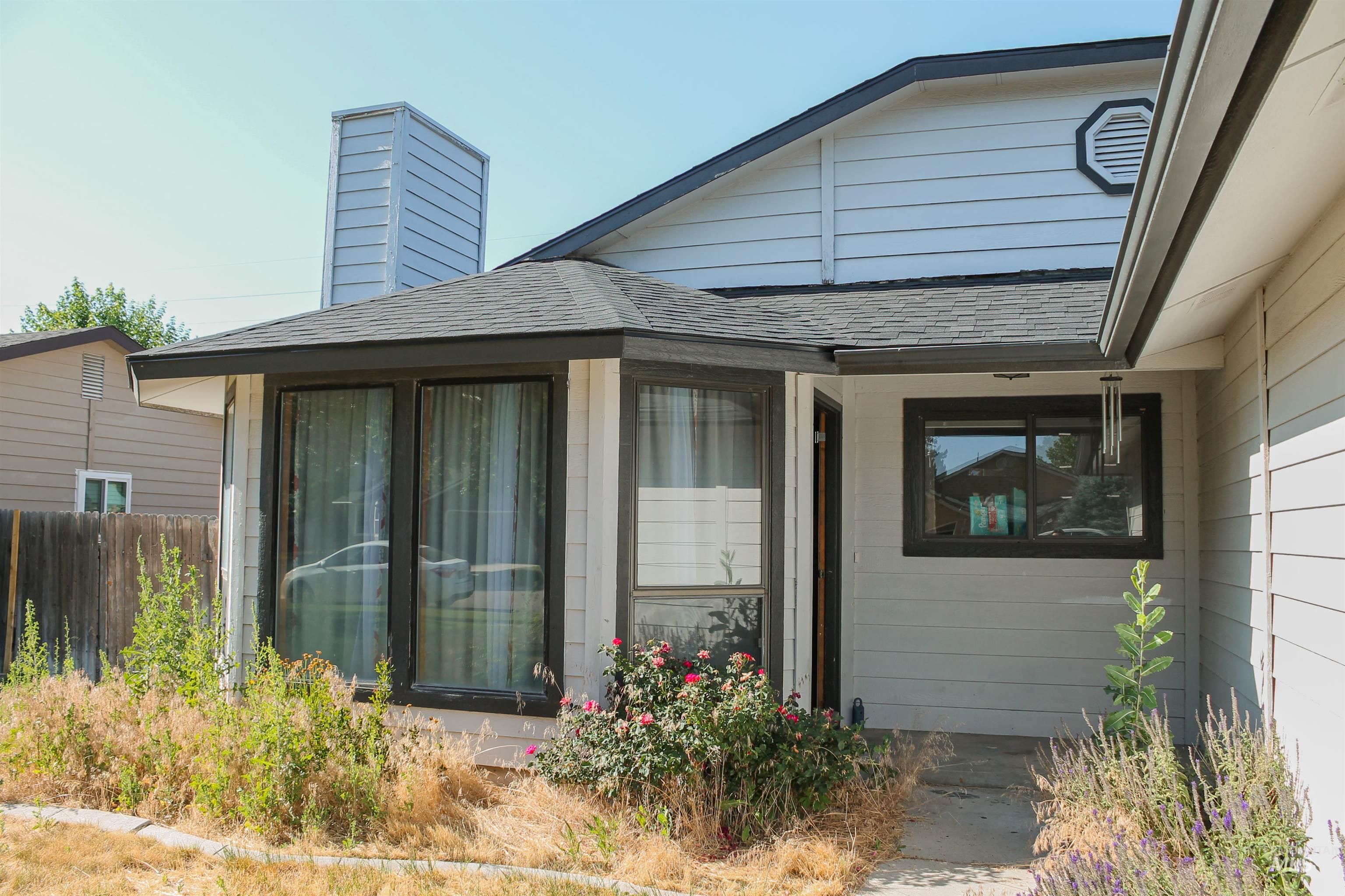Property entrance with roof with shingles and a chimney