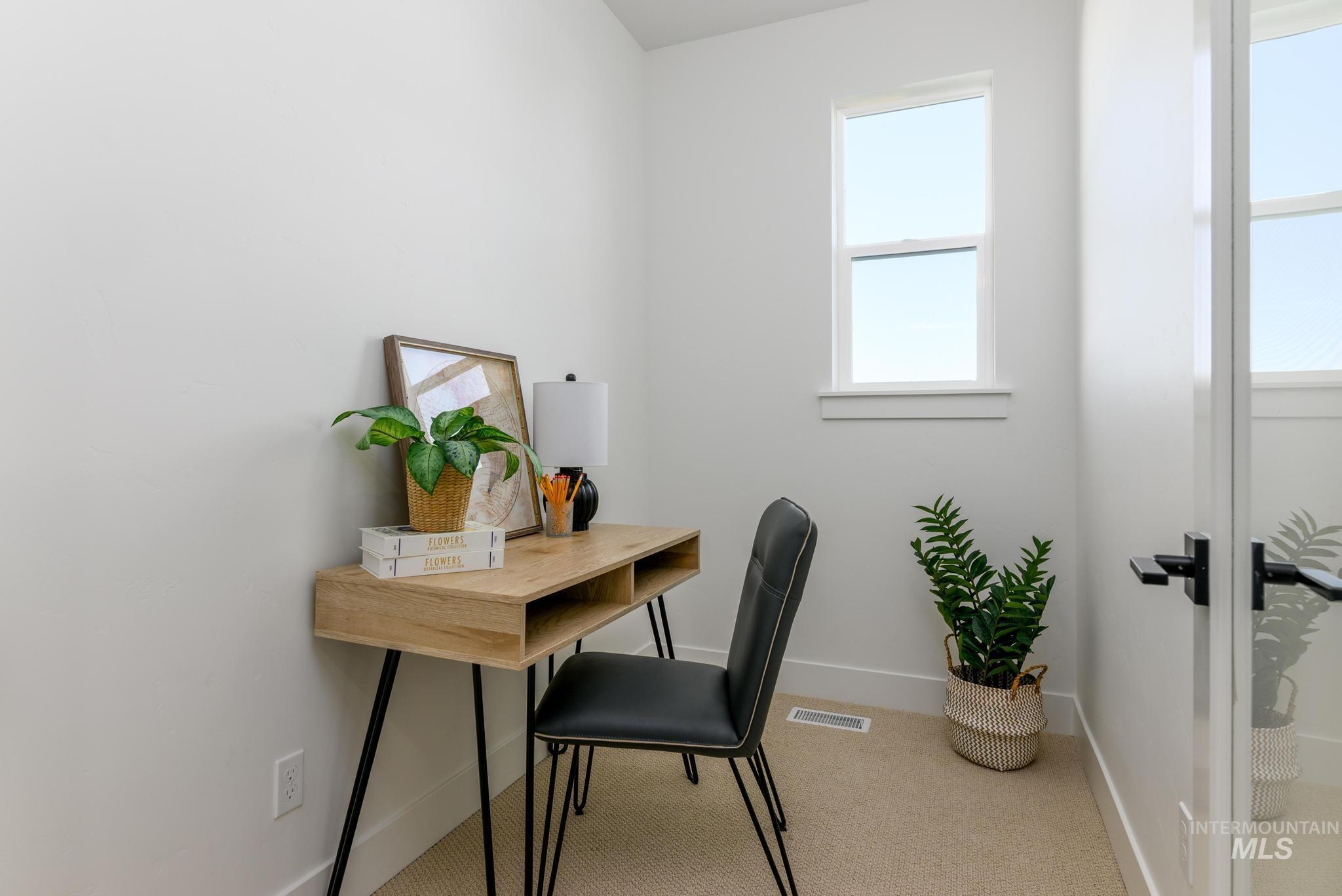 Office space featuring light colored carpet and baseboards