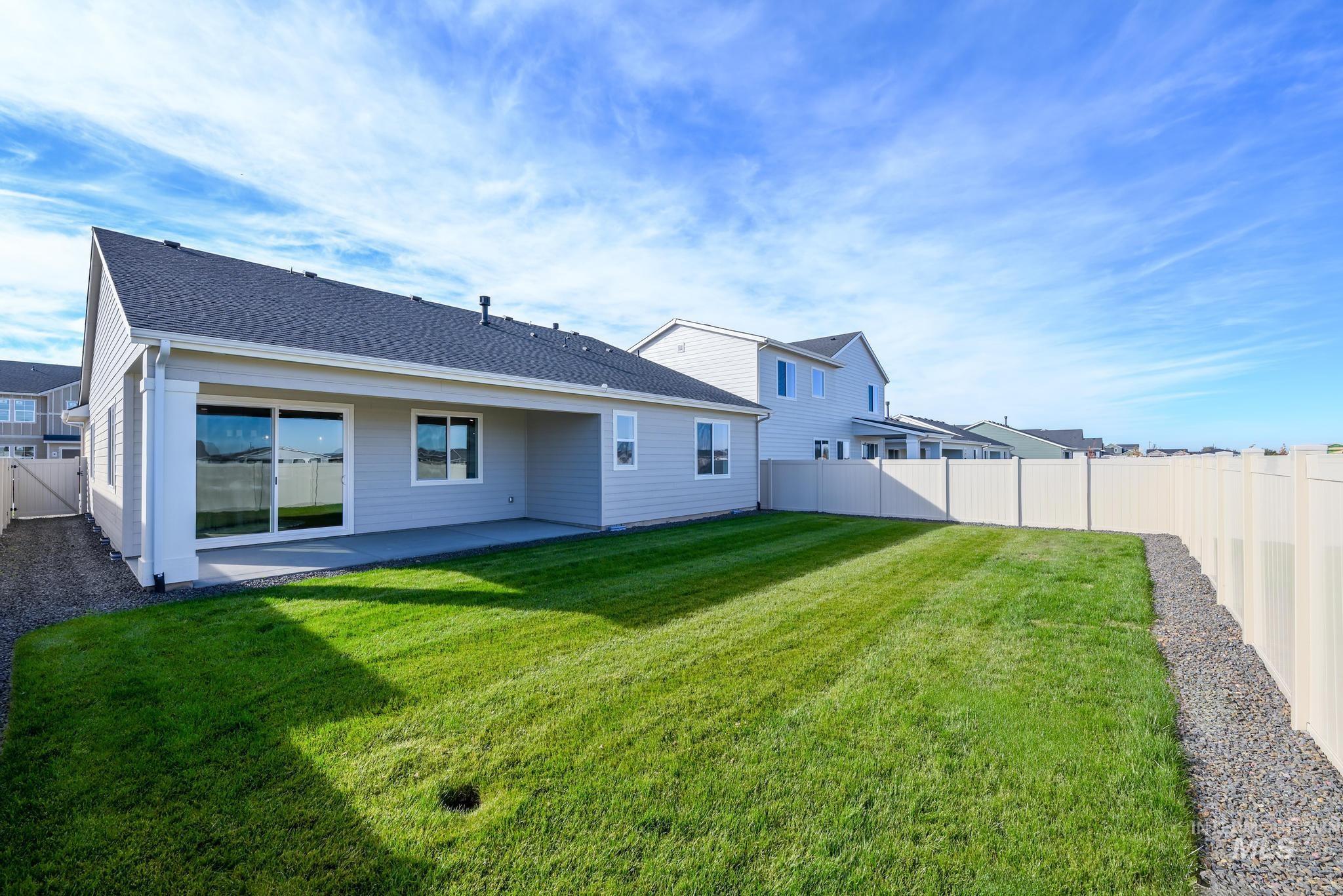 Back of house featuring a fenced backyard, a patio, and a shingled roof