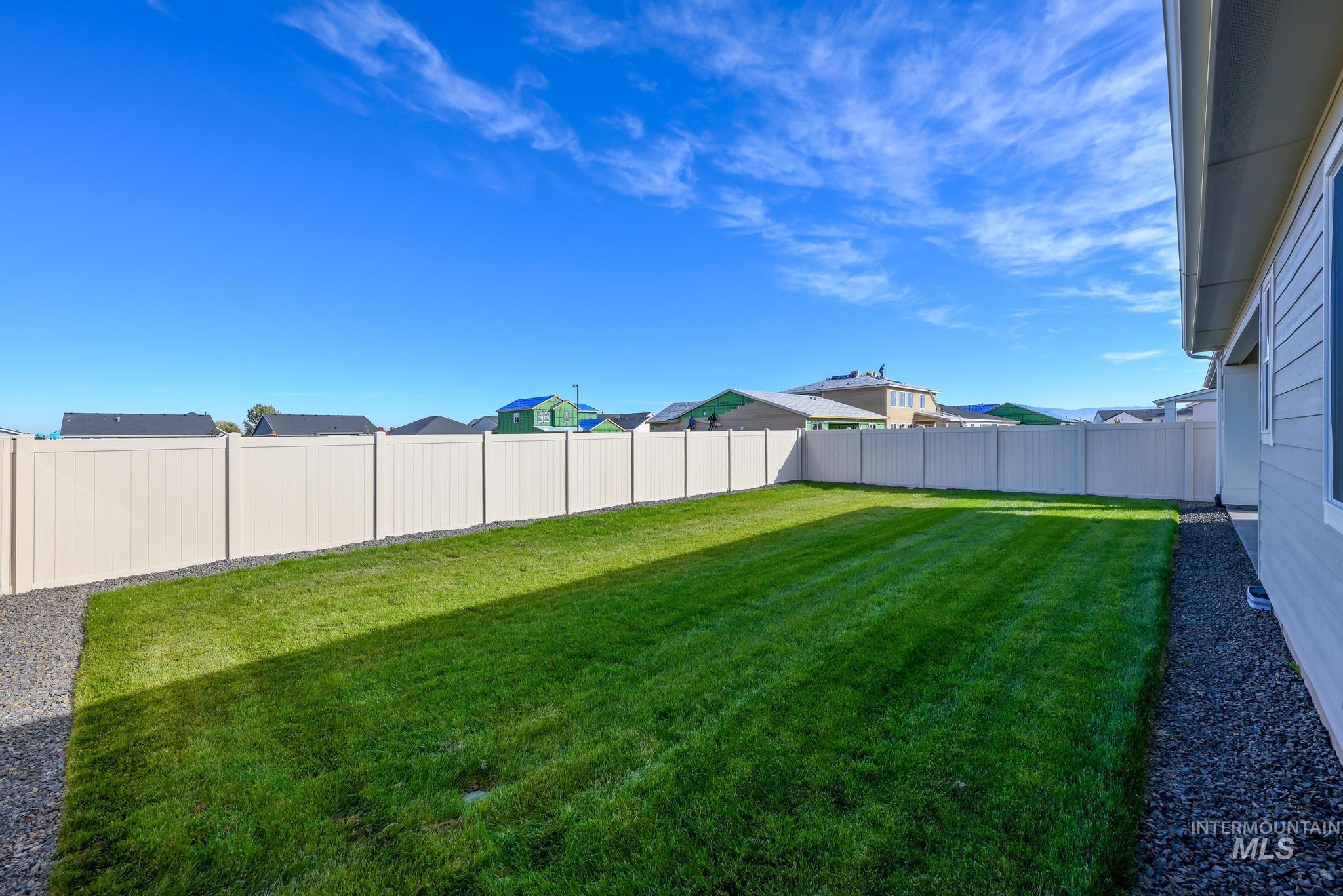 Fenced backyard featuring a residential view