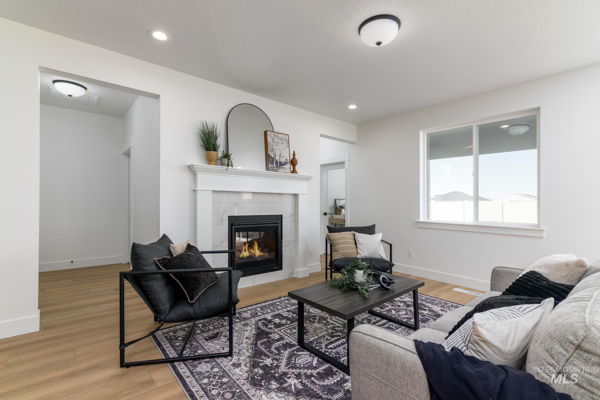 Living area featuring light wood-type flooring, a fireplace, and recessed lighting