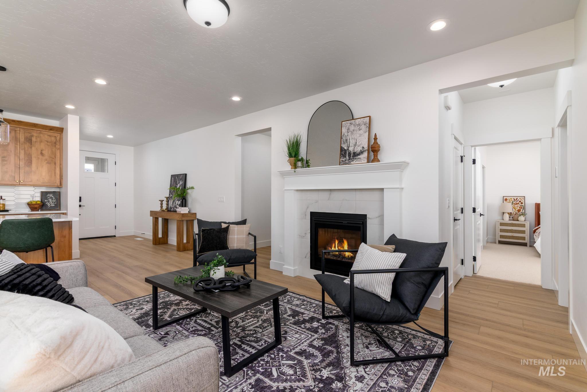 Living room featuring light wood-type flooring, recessed lighting, and a tile fireplace