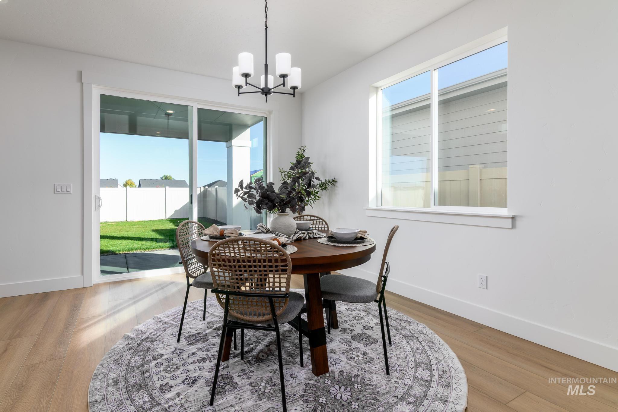 Dining room with light wood-style flooring and a chandelier