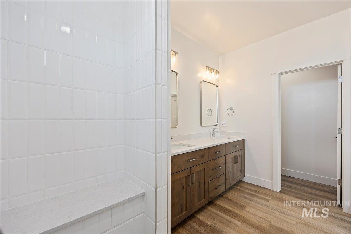 Bathroom featuring double vanity and wood finished floors