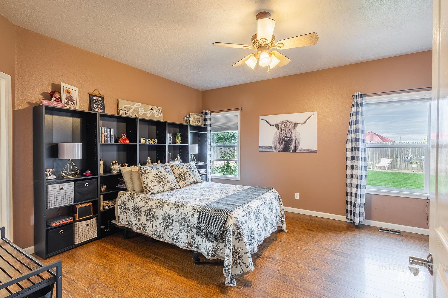 Bedroom featuring wood finished floors, ceiling fan, and a textured ceiling