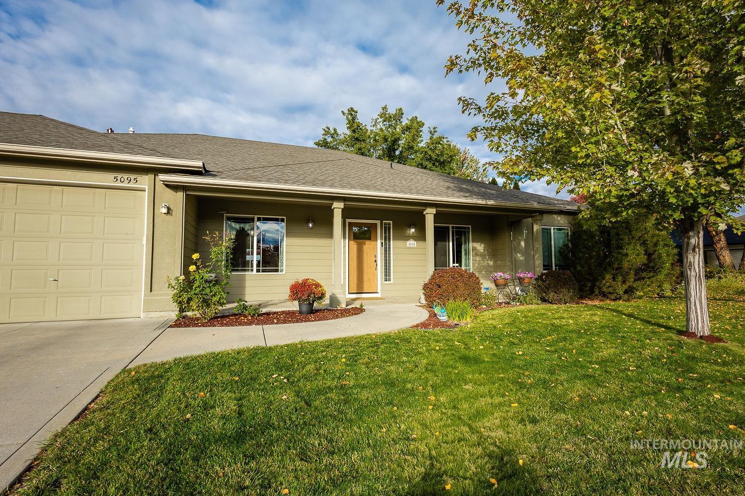 Single story home featuring a front yard, a shingled roof, covered porch, a garage, and concrete driveway