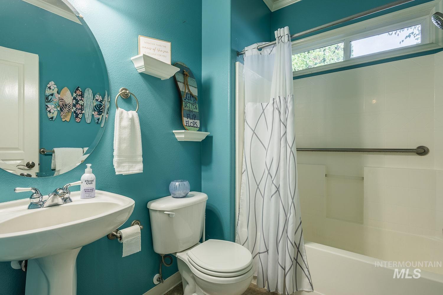 Bathroom with shower / bath combination with curtain and crown molding