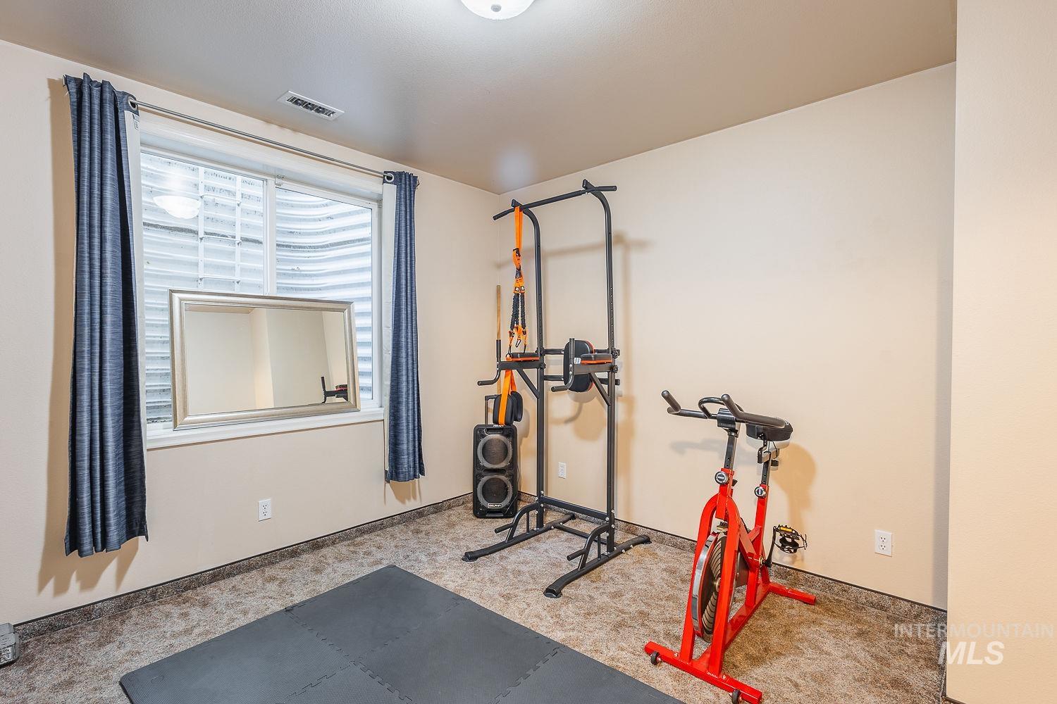 Workout room with baseboards and carpet floors