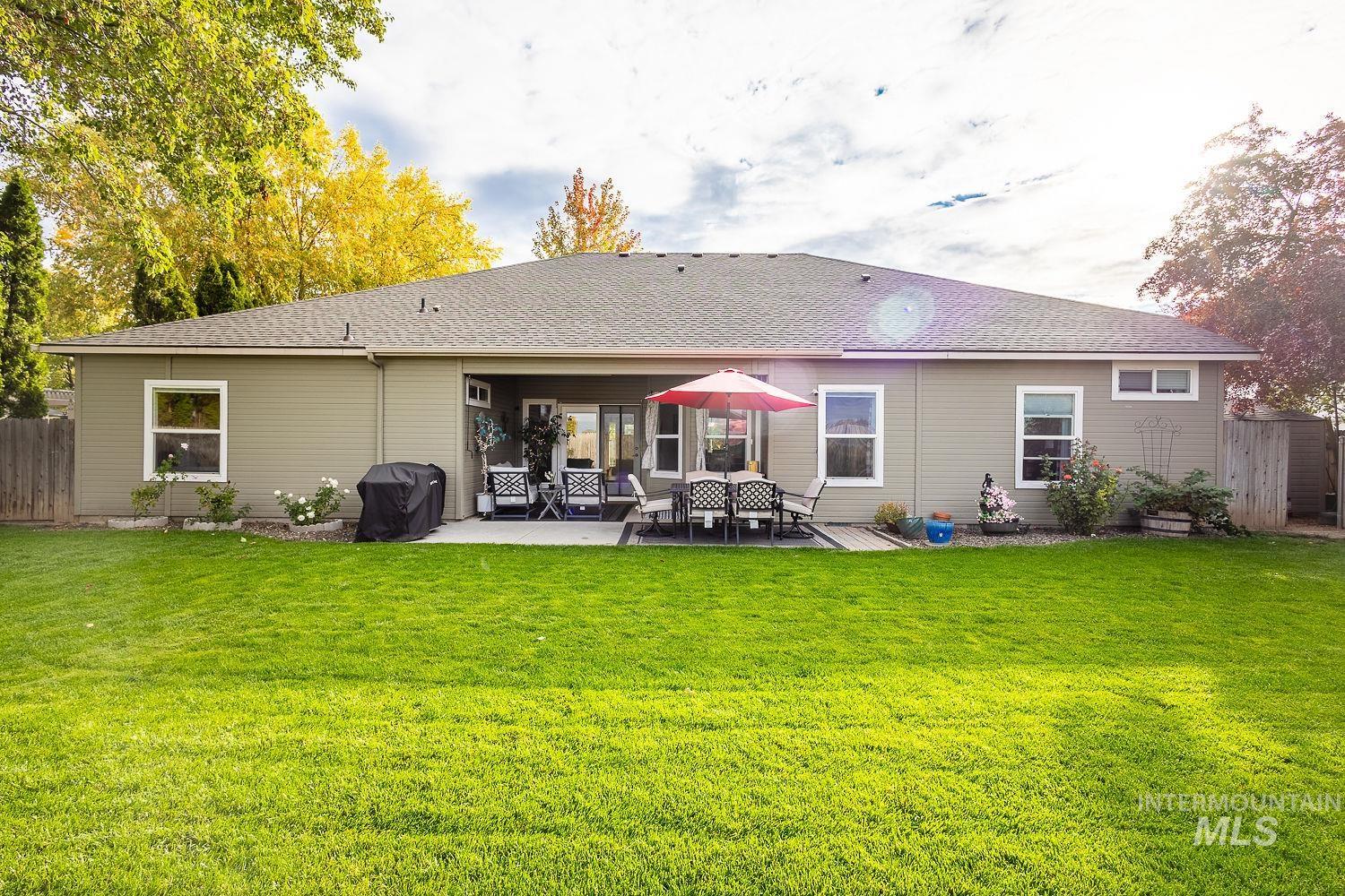 Rear view of house featuring roof with shingles and a patio