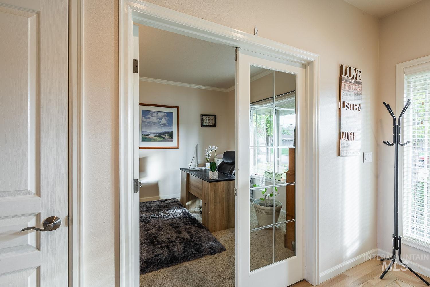 Doorway featuring plenty of natural light, wood finished floors, and crown molding