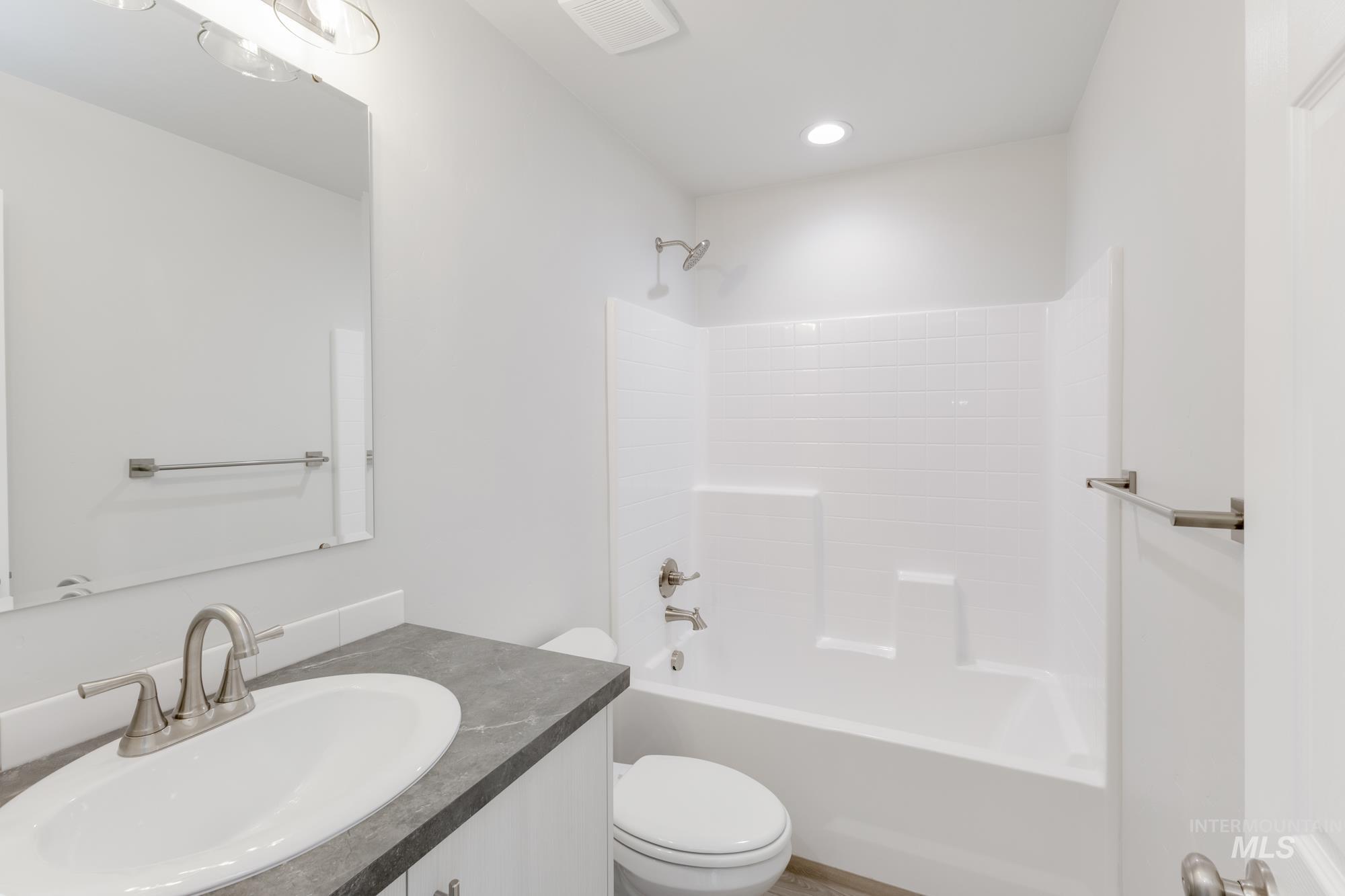 Bathroom with vanity, shower / washtub combination, and recessed lighting