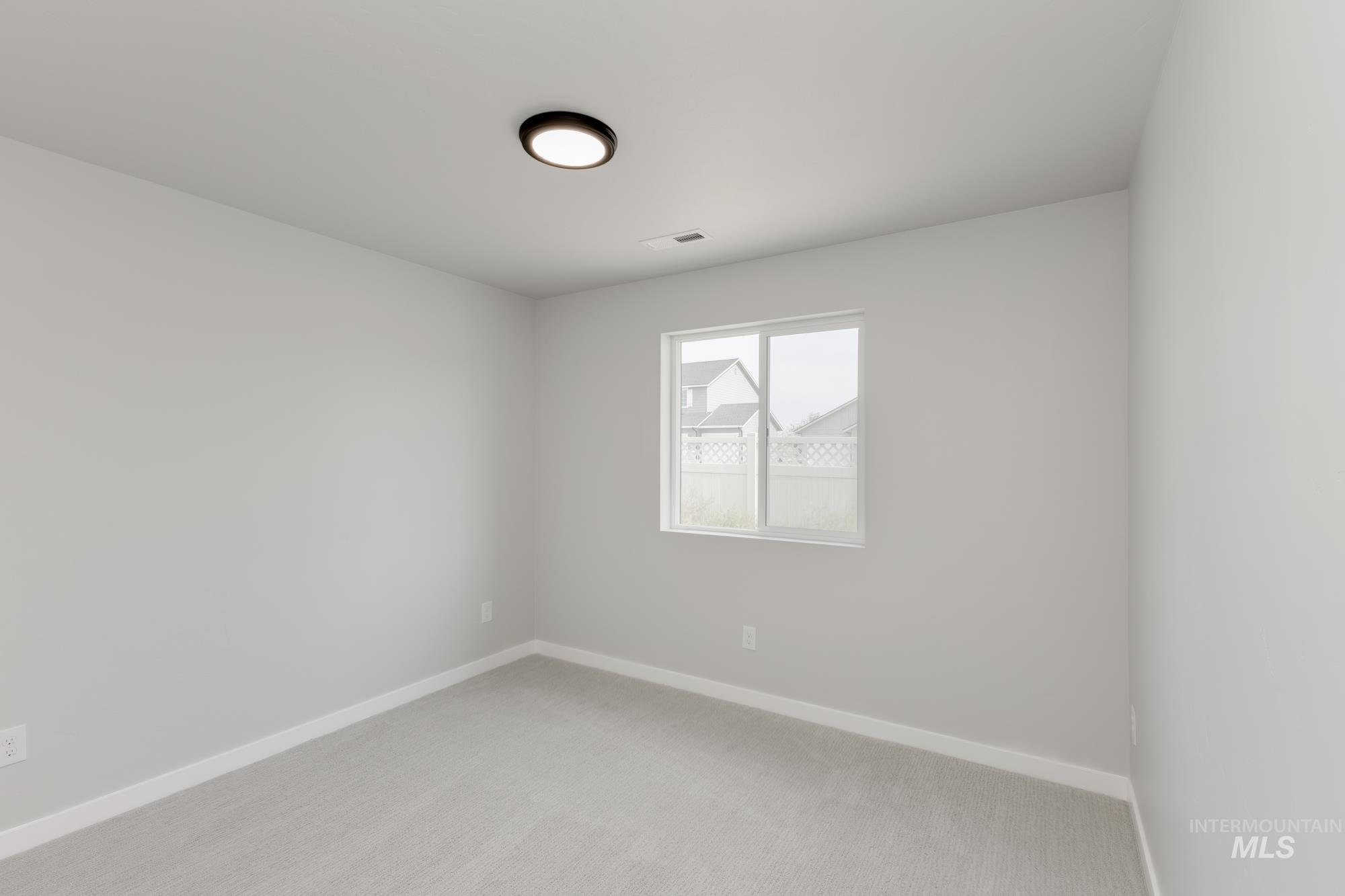 Unfurnished room featuring baseboards and light carpet