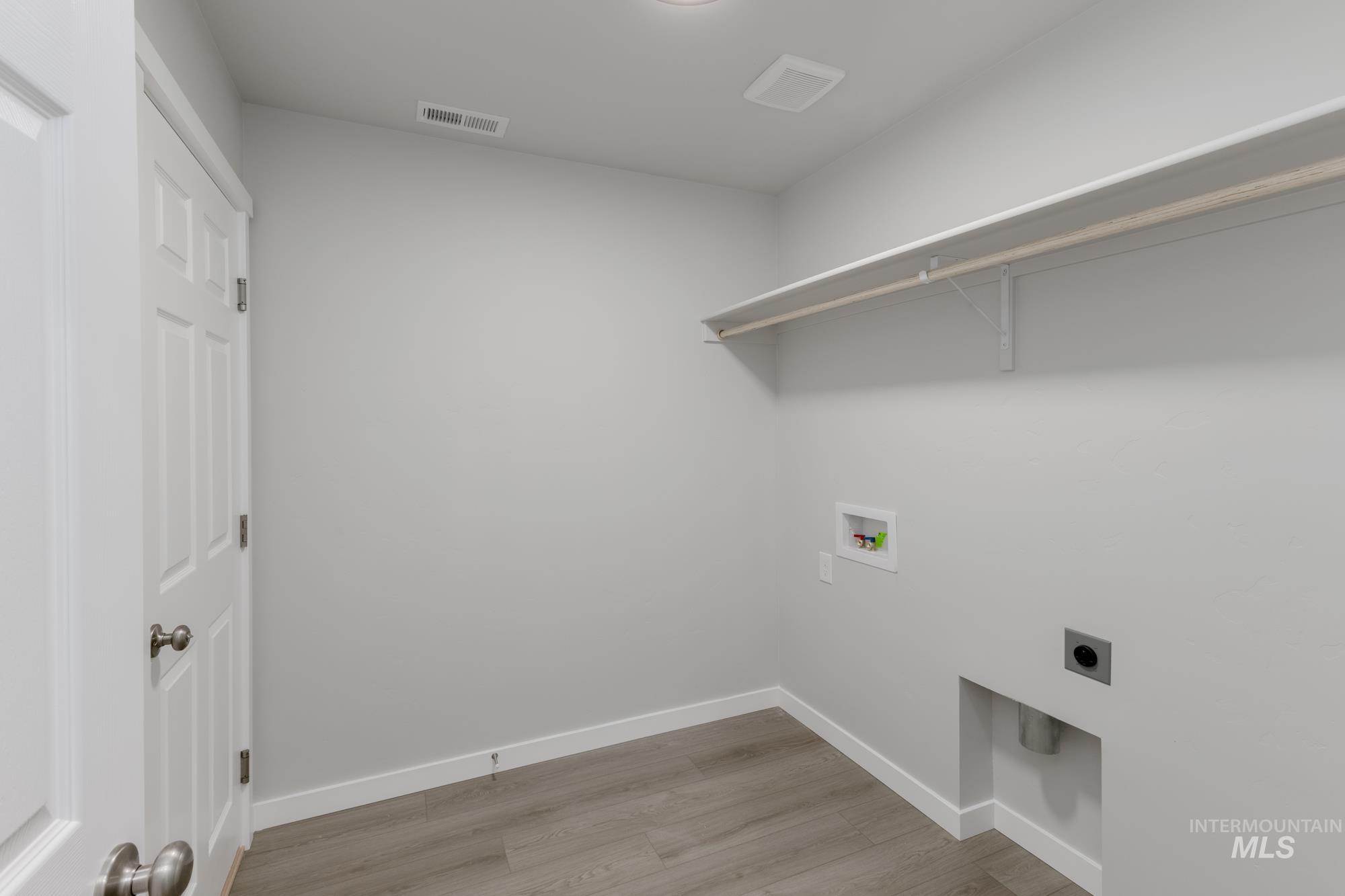Laundry room with hookup for an electric dryer, washer hookup, and light wood-style floors