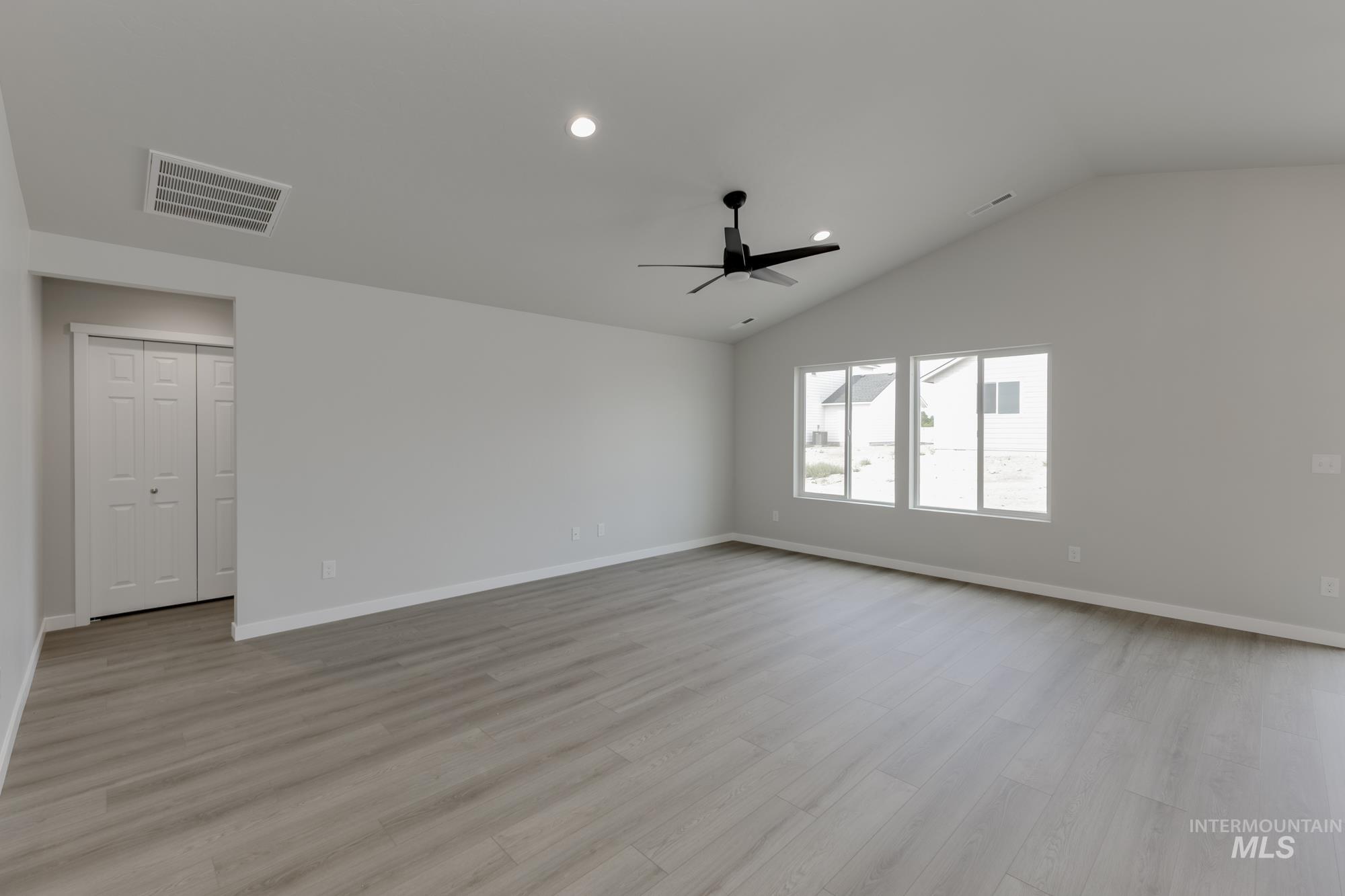 Unfurnished room featuring ceiling fan, light wood-style flooring, vaulted ceiling, and recessed lighting