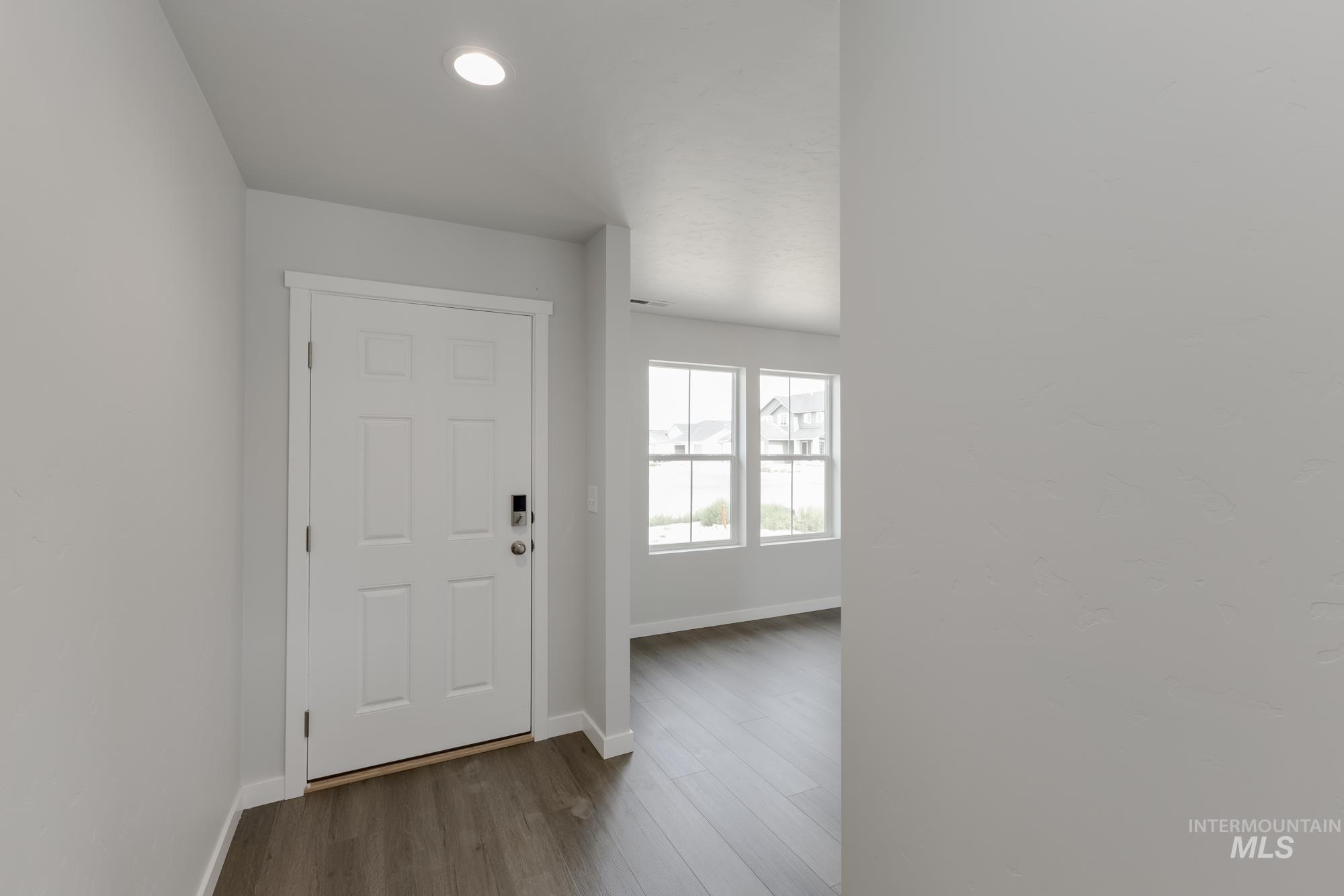 Foyer featuring dark wood-style flooring and recessed lighting