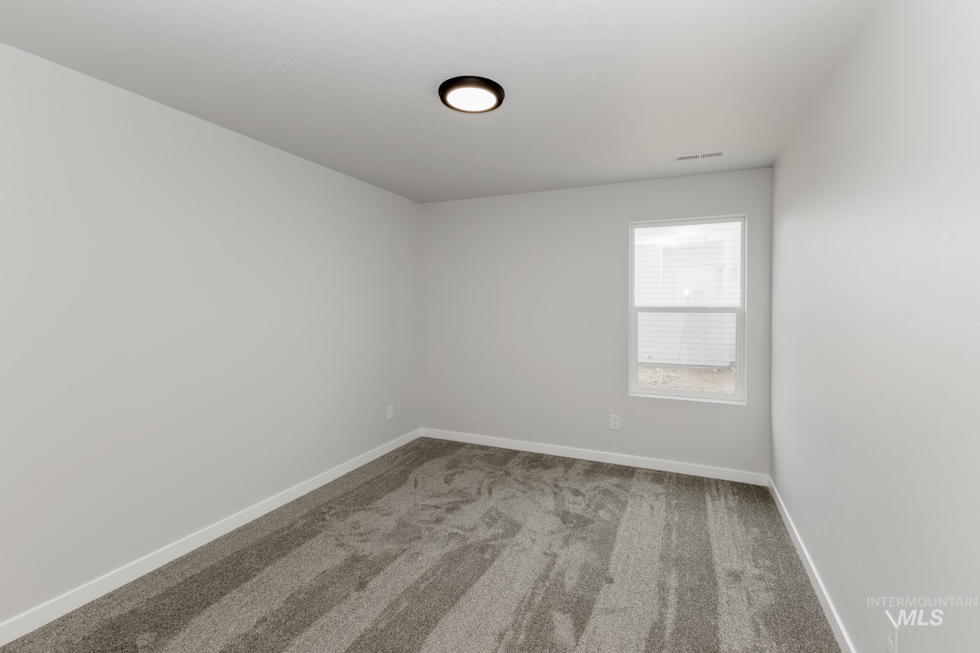 Carpeted empty room with baseboards