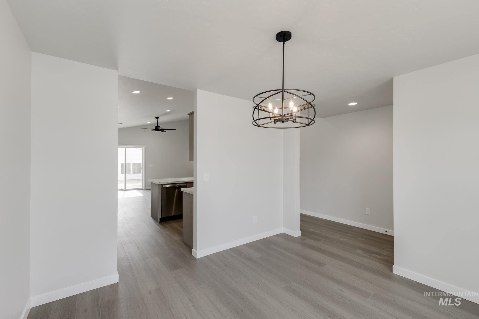 Unfurnished dining area with light wood-style floors, recessed lighting, a chandelier, and a ceiling fan