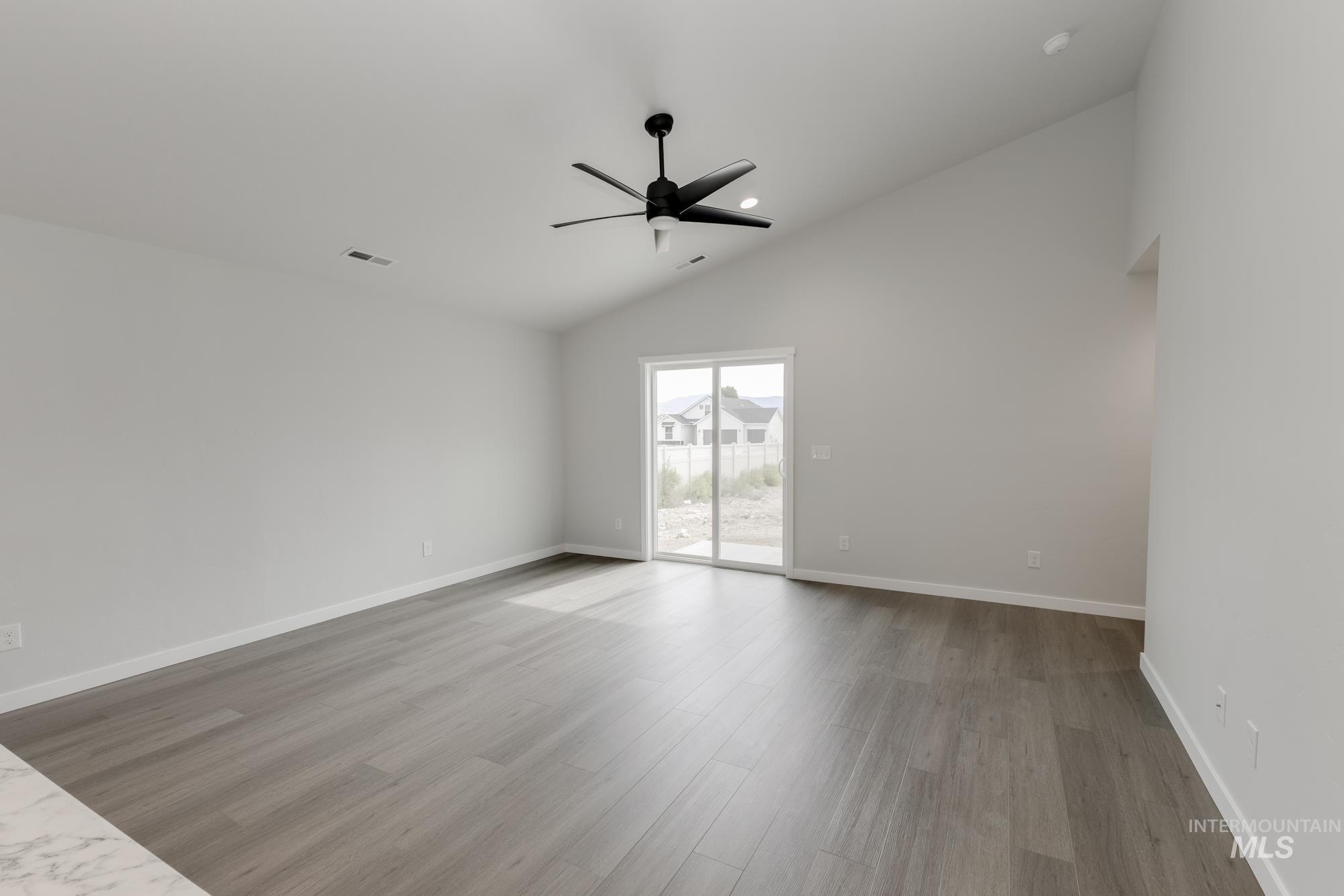 Spare room featuring ceiling fan, high vaulted ceiling, wood finished floors, and recessed lighting