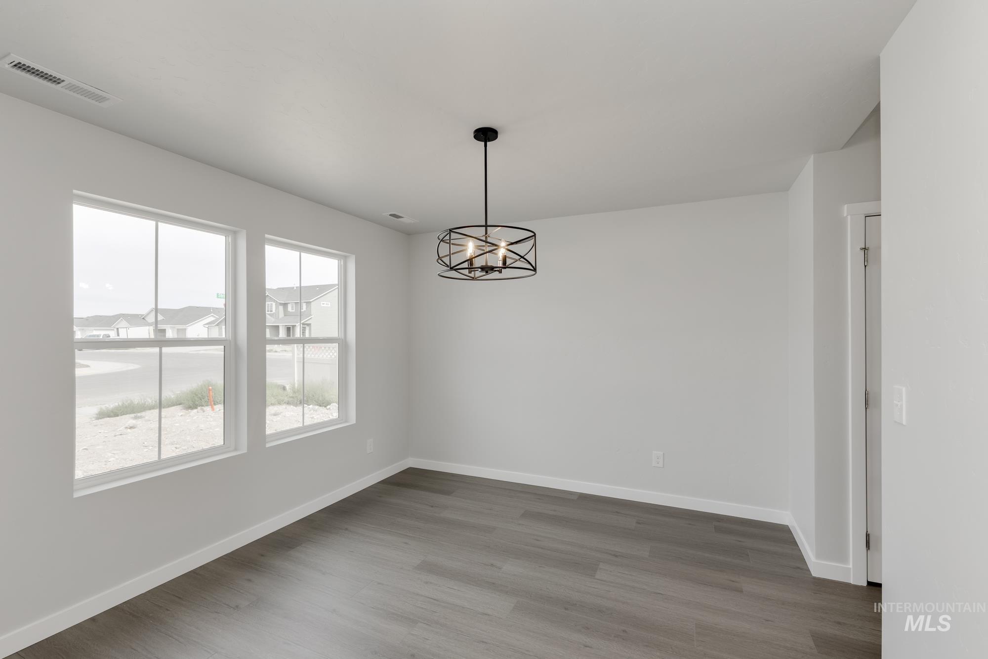 Spare room featuring a chandelier and wood finished floors