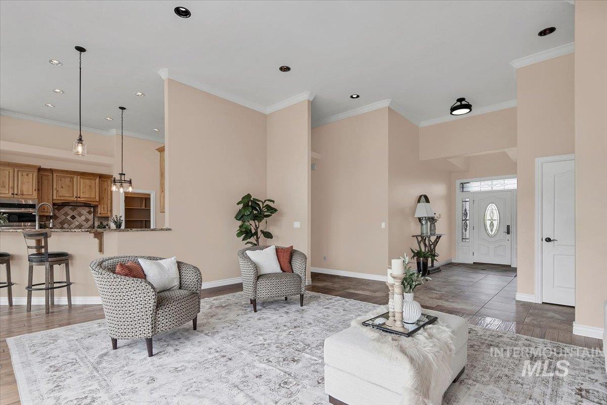 Living area with ornamental molding, recessed lighting, and wood finished floors
