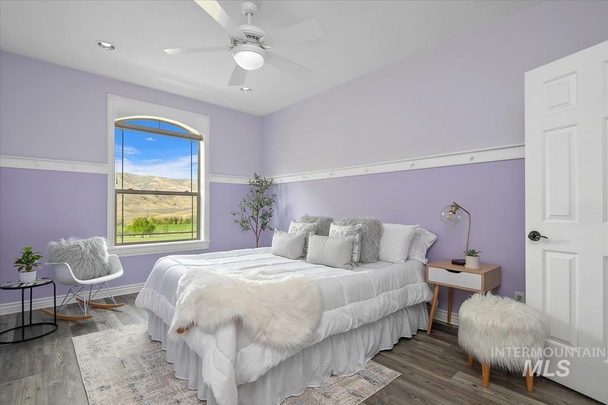 Bedroom featuring a ceiling fan, wood finished floors, a mountain view, and recessed lighting