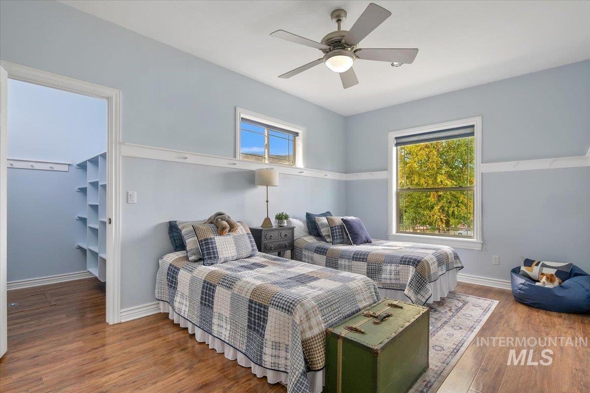Bedroom featuring wood finished floors, ceiling fan, and a spacious closet