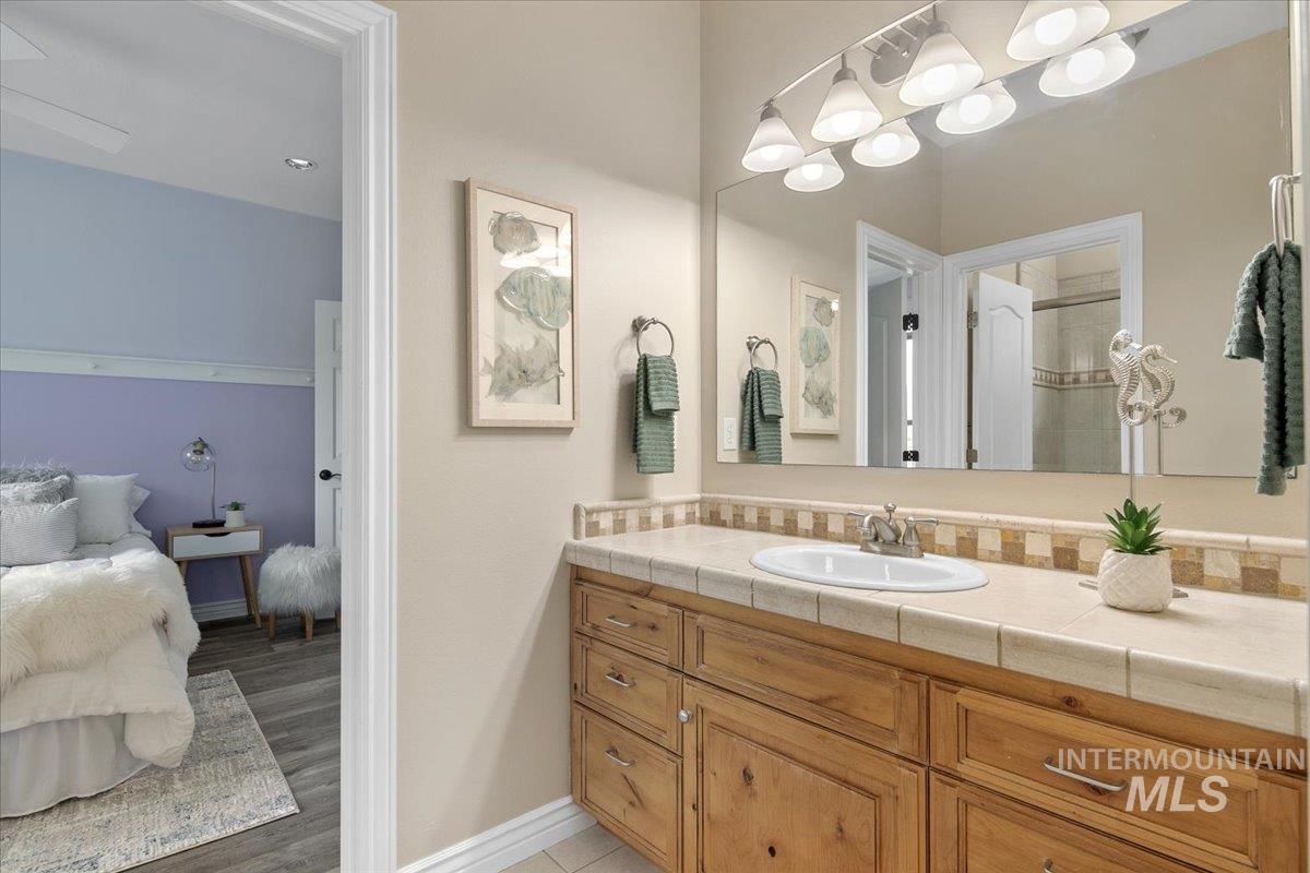 Bathroom featuring vanity, light wood finished floors, and ensuite bathroom