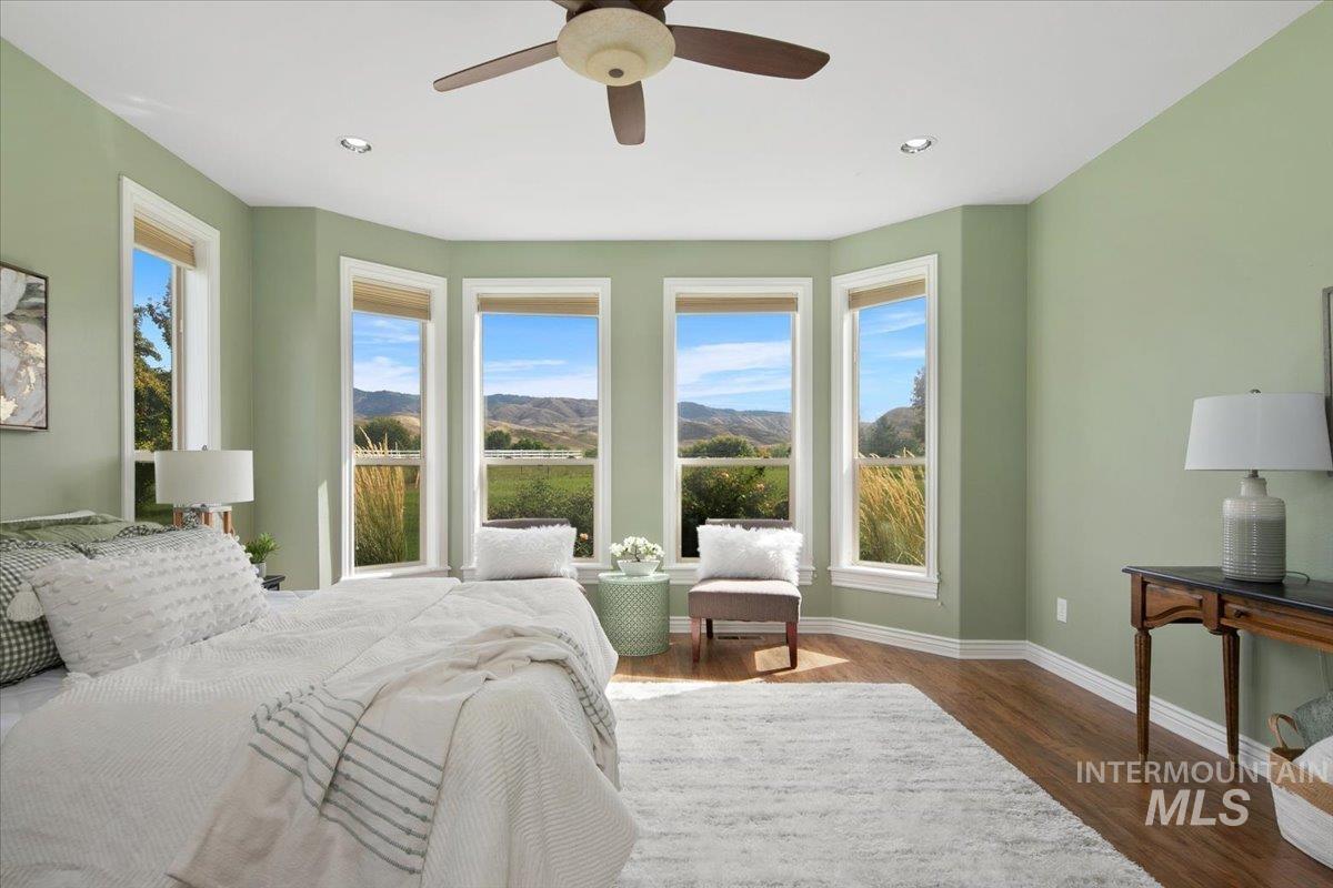 Bedroom with dark wood-style floors, multiple windows, a mountain view, ceiling fan, and recessed lighting