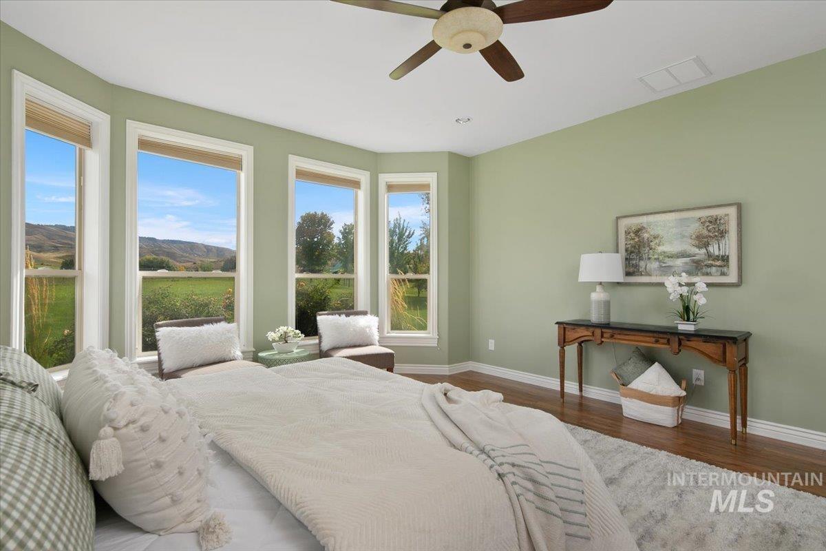Bedroom featuring wood finished floors, a ceiling fan, and a mountain view
