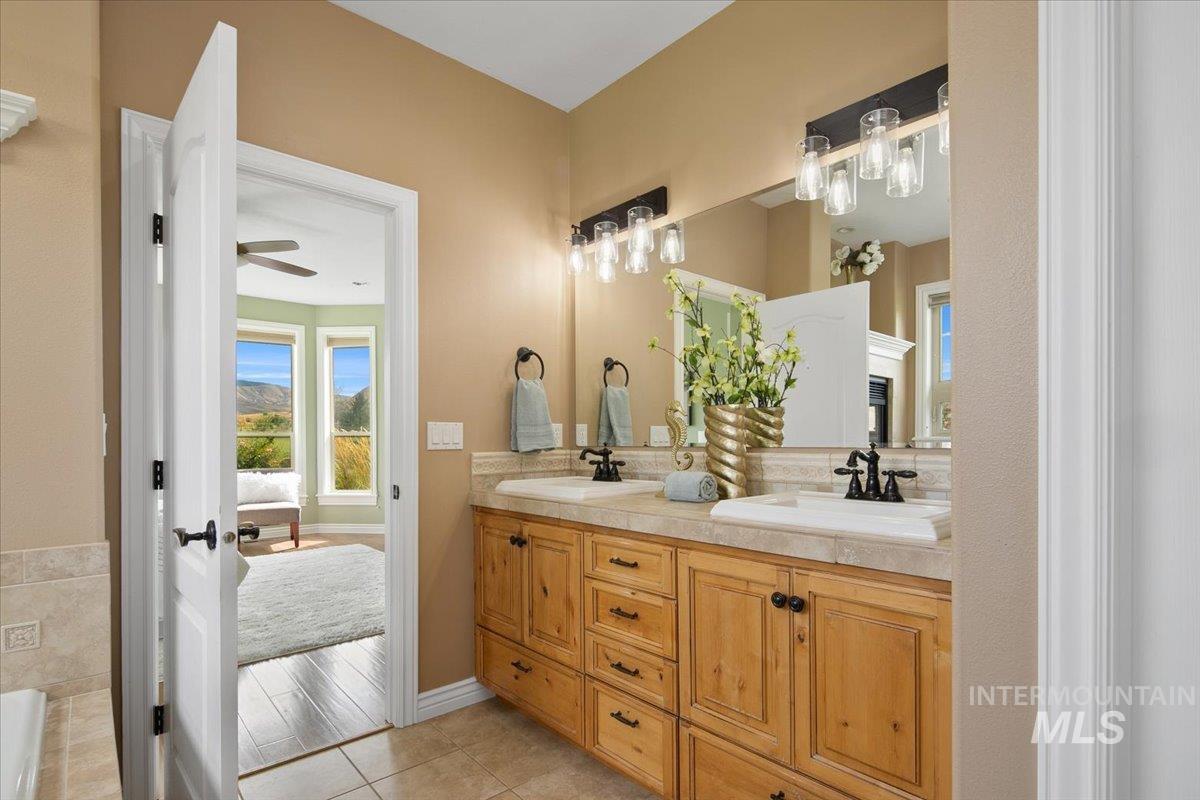 Full bathroom with double vanity and light tile patterned floors