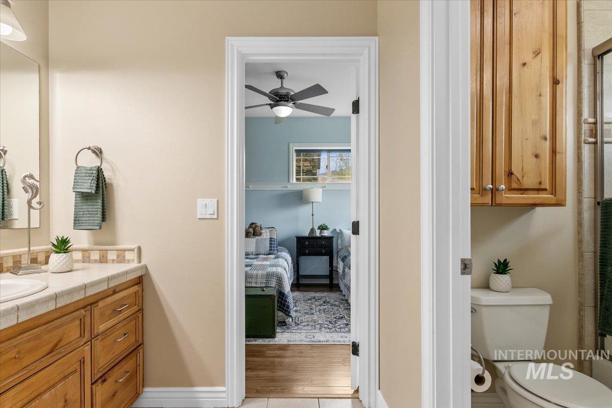 Ensuite bathroom featuring vanity and ceiling fan