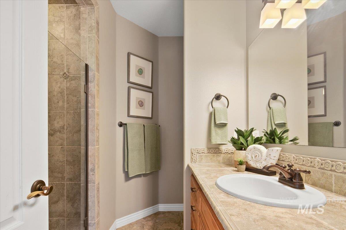 Full bath featuring vanity and a shower stall