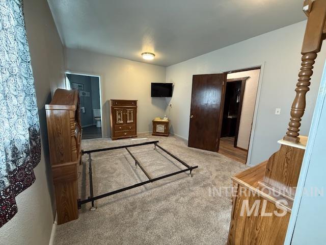 Bedroom featuring carpet flooring and baseboards